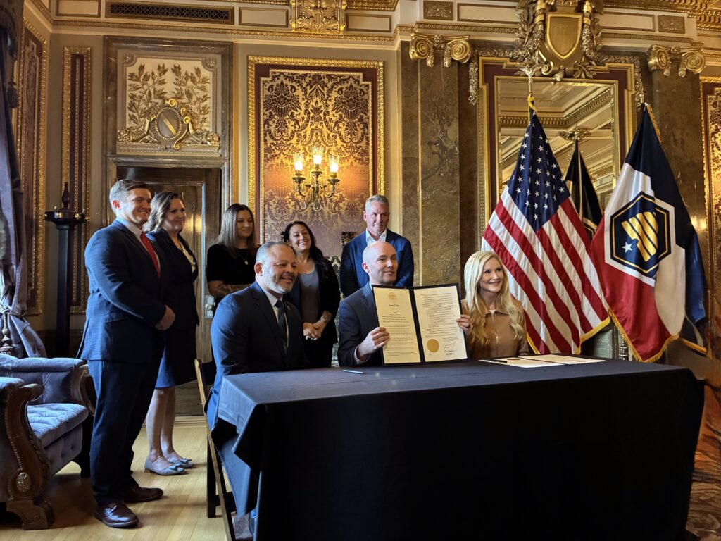 Gov. Spencer Cox poses with dignitaries from Utah and Washington DC with his executive order for the Utah Recovery Initiative.